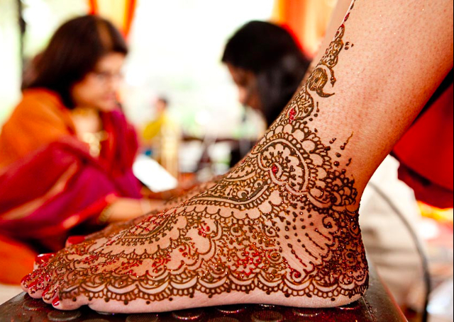 Latest Mehandi Bridal Design featuring peacock motif  and glitter